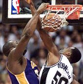Shaquille O'Neal dunks the ball over David Robinson